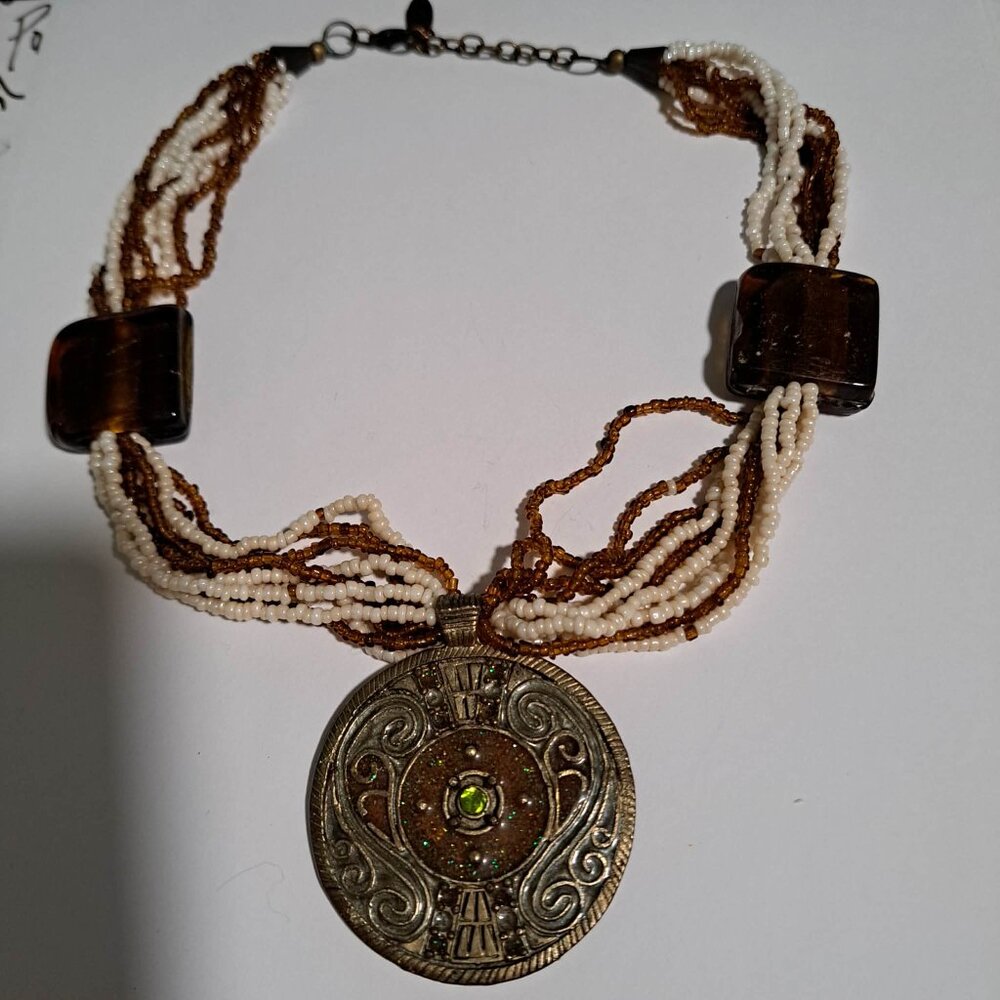 Caracol brown and white multistrand beaded necklace with a large round pendant